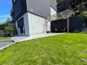卑尔根Apartment Lilletveitvegen的前面有绿色草坪的房子