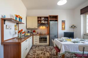 加利亚诺德尔卡波Casa Libeccio的厨房配有桌子和冰箱