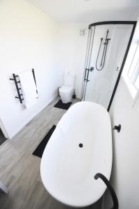 陶波Premium Comfortable Lake View 2BR的白色的浴室设有白色的卫生间和淋浴。