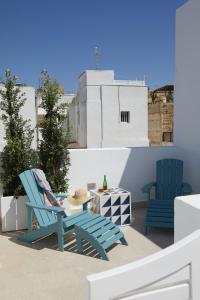 塔里法El Escondite Tarifa的阳台上配有2把蓝色椅子和一张桌子