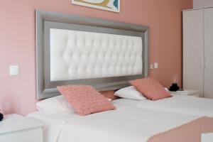 维辛达里奥Resort Suites Vecindario的一间卧室配有两张粉红色墙壁的床