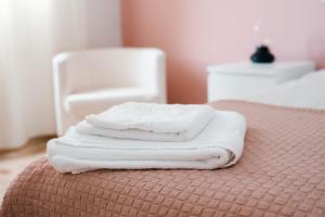 维辛达里奥Resort Suites Vecindario的床上堆放了三条白色毛巾