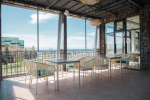 乔尔蓬阿塔Silence hotel的阳台配有桌椅和窗户。