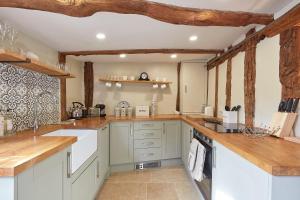 萨德伯里Copper Cottage in Clare的一间设有白色橱柜和木梁的大厨房
