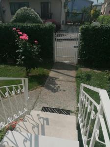 米拉Casa Cairoli的粉红色玫瑰的院子前的白色门