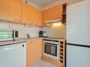 拉波勒Apartment Mariza - LAU302 by Interhome的厨房配有木制橱柜和白色冰箱。
