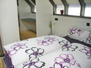 胡芬根许芬根度假屋的一间卧室,床上有紫色鲜花