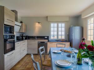 LandunvezHoliday Home Saint Gonvel - LDZ103 by Interhome的厨房配有桌椅和冰箱。