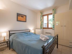 圣艾格夫Apartment Le Mas des Calanques-1 by Interhome的一间卧室设有蓝色的床和窗户。