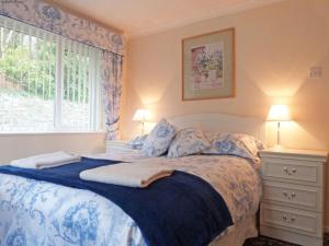 多尔盖罗Holiday Home Robins House by Interhome的一间卧室配有一张带蓝色和白色床单的床和窗户。