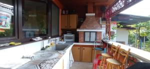 拉夫达стаи за гости Росица的厨房配有水槽和带椅子的柜台。