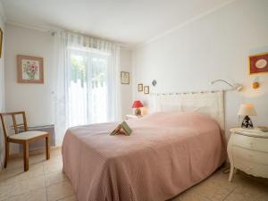 圣艾格夫Apartment Le Grand Parc-5 by Interhome的白色卧室配有粉红色的床和椅子