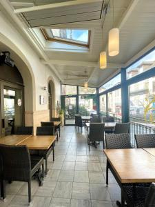 拉卡努尔格斯塔迪勒酒店的餐厅设有木桌、椅子和窗户。
