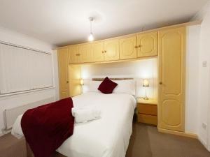 NitshillCozy Nights SVP Detached House的卧室配有带红色枕头的大型白色床