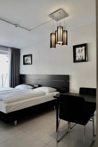 奥斯陆Super Stay Hotel, Oslo的一间卧室配有一张床、一张书桌和一个吊灯。