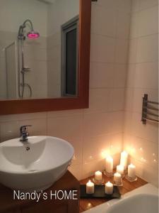 Odza IINandy's home的浴室设有水槽、镜子和蜡烛