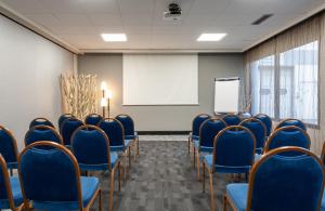 马恩河畔博纳伊克雷泰伊马恩河畔波涅基里亚德酒店的一间会议室,配有蓝色椅子和白色板