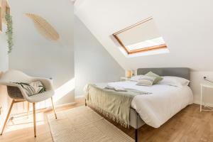 朗贝萨尔Le Cottage de l'Hippodrome.的白色卧室配有床和椅子