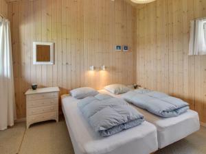 瓦伊厄斯斯特兰德Holiday Home Steni - 250m from the sea in Western Jutland by Interhome的配有木墙和桌子的客房内的两张床