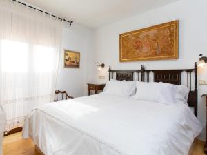 NigüelasHoliday Home La Casita de Elvira by Interhome的卧室配有一张白色床,墙上挂有绘画作品