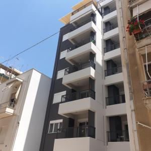 雅典Elvita Apartments 4的公寓大楼设有阳台,享有蓝色的天空