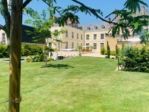 拉弗雷切Les Chambres de La Varenne的享有带草地庭院的大房子的景色