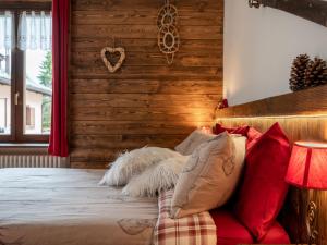 普拉利Apartment Il Fior di Neve by Interhome的一间卧室设有木墙和一张带枕头的床。