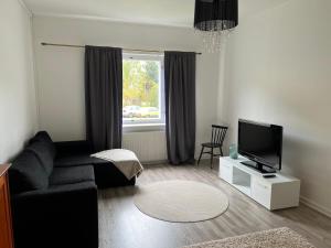科科拉Apartment Huvilakatu的客厅配有黑色沙发和电视