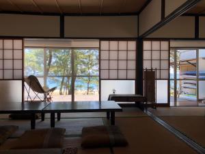 Kitsuki奈多みどり荘 Nada Beach House的客房设有桌子、椅子和窗户。
