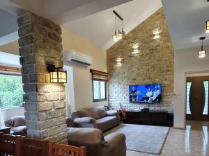 达夫纳Huge & Private Villa In Kibbutz Dafna的带沙发和石墙的客厅