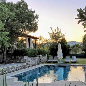 奥塔肯特Authentic Bodrum Villa with Special Private Pool的一个带两把椅子和遮阳伞的游泳池