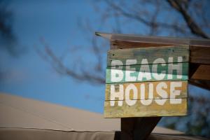 圣伦纳兹Glamping at Back Of Beyond Touring Park的读海滩房屋的标志