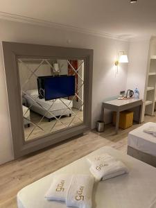 马尔马里斯FİFTY5 SUİTE HOTEL的客房设有两张床和镜子内的电视