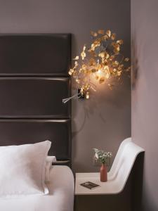 巴黎Legend Hôtel Paris的一间卧室配有一张床和一张带台灯的桌子
