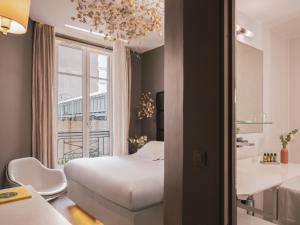巴黎Legend Hôtel Paris的一间卧室配有一张床,浴室设有窗户