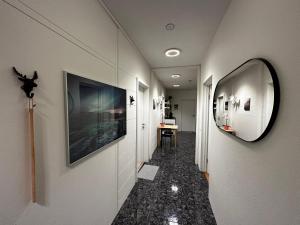 雷克雅未克Johann´s Guesthouse的走廊上设有镜子,走廊上设有桌子