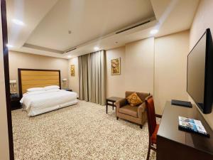 多哈Grand Legacy Hotel Doha的酒店客房配有一张床、一张桌子和一把椅子。