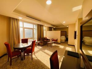 多哈Grand Legacy Hotel Doha的酒店客房设有桌椅和一间卧室。
