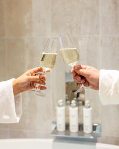 爱丁堡RÌGH Properties - Luxury West End Artisan Apartment的两人在浴室内拿着白葡萄酒