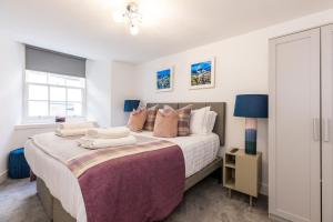 爱丁堡RÌGH Properties - Luxury West End Artisan Apartment的一间卧室配有一张带枕头的大床