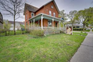 马尼斯蒂Dtwn Victorian Home - 1 Mi to Lake Michigan Beach!的院子中带围栏的大型砖房