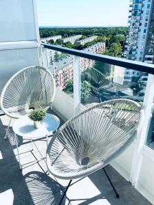 格但斯克Apartament z Widokiem na Morze的阳台配有2把椅子和1张桌子