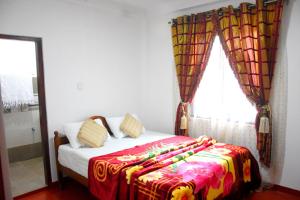 纳奥亚Ansi Villa的一间卧室配有一张带彩色毯子的床