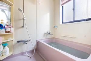 川崎Noriko's Home - Vacation STAY 13624的一间带粉色浴缸和窗户的浴室