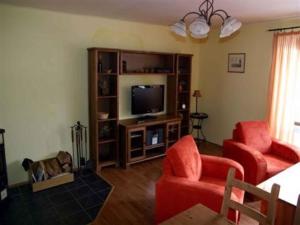 韦尔卡乌帕Holiday home in Pec pod Snezkou 2156的客厅配有2把红色椅子和电视