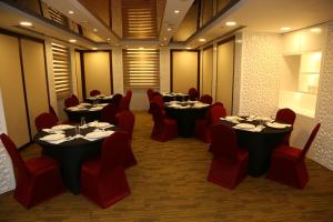 多哈Grand Legacy Hotel Doha的用餐室配有桌子和红色椅子