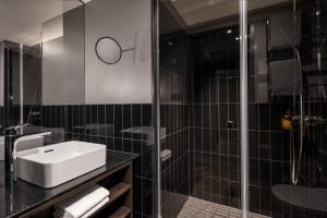 柏林Hotel ROMY by AMANO的一间带水槽和玻璃淋浴的浴室