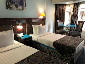 开罗开罗桑塔纳酒店的酒店客房带两张床和一张桌子以及椅子。