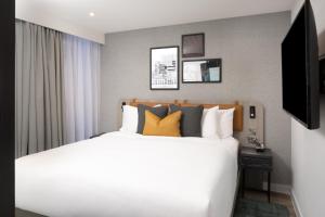 曼彻斯特Residence Inn by Marriott Manchester Piccadilly的卧室配有一张带黄色枕头的大型白色床。