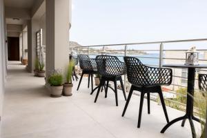 斯塔里斯Niro Beachfront Living的阳台配有桌椅,享有海景。